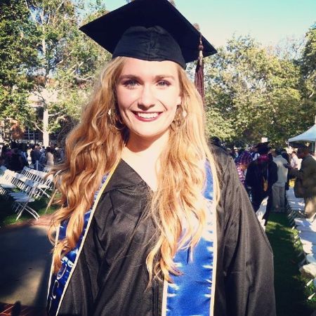 Taylor Patterson is posing in her graduation gown.
